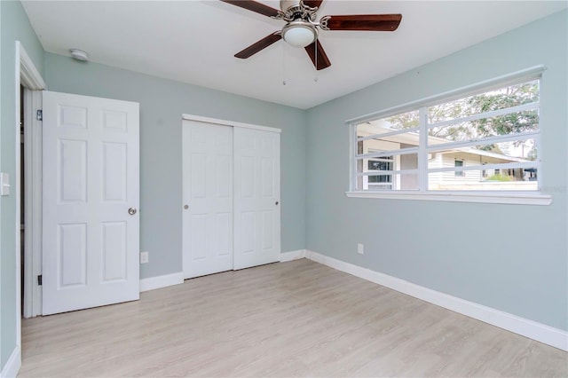 unfurnished bedroom featuring ceiling fan, light wood-type flooring, and a closet