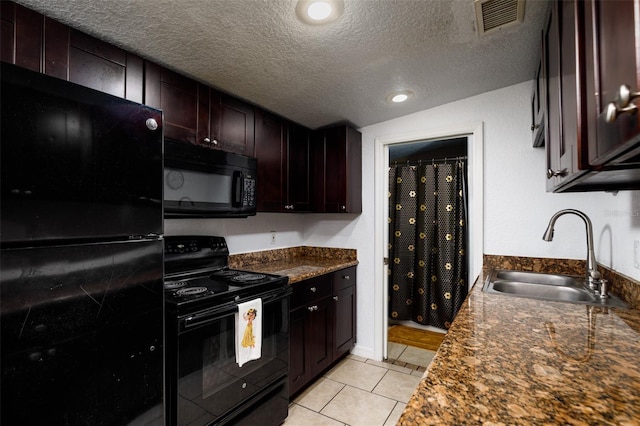 kitchen featuring a textured ceiling, sink, light tile patterned floors, black appliances, and dark brown cabinetry