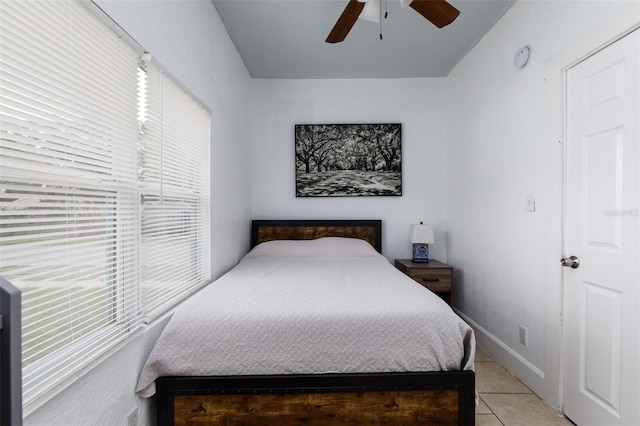 bedroom with light tile patterned floors, a ceiling fan, and baseboards