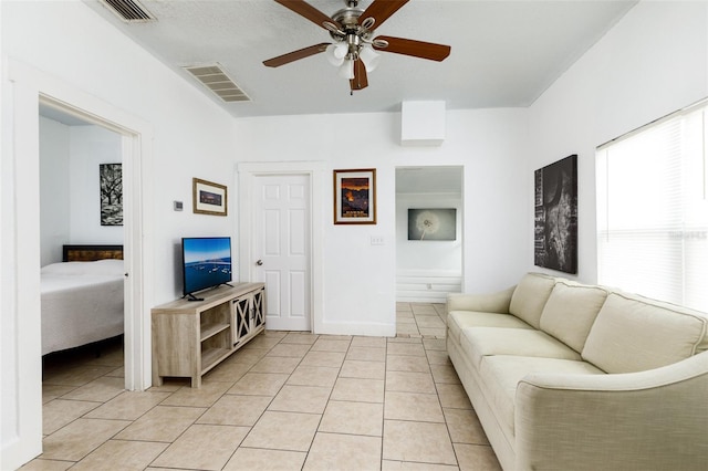 living area with light tile patterned flooring, visible vents, and ceiling fan