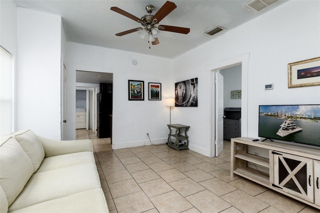 living room featuring a textured ceiling, ceiling fan, and light tile patterned floors