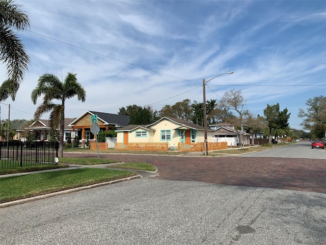 view of street with street lights, curbs, sidewalks, and a residential view