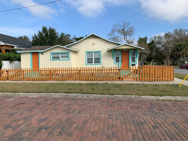 view of front of home with a fenced front yard and stucco siding