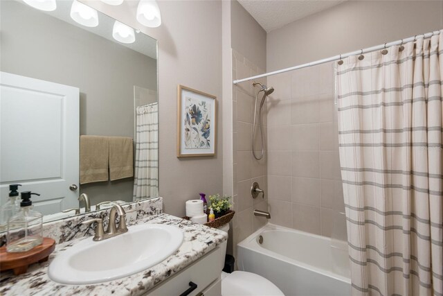 full bathroom featuring a textured ceiling, toilet, vanity, and shower / tub combo