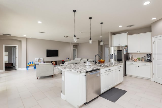 kitchen with sink, appliances with stainless steel finishes, an island with sink, and white cabinetry