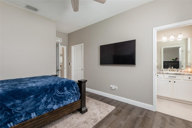 bedroom featuring ensuite bathroom, ceiling fan, dark wood-type flooring, and sink