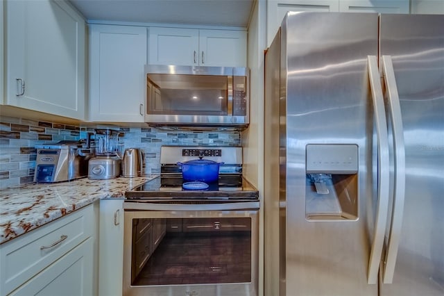 kitchen with appliances with stainless steel finishes, backsplash, and white cabinetry