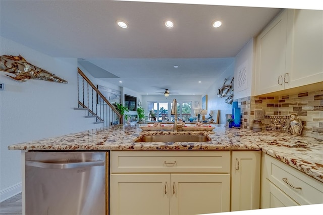 kitchen featuring dishwasher, light stone countertops, kitchen peninsula, ceiling fan, and sink