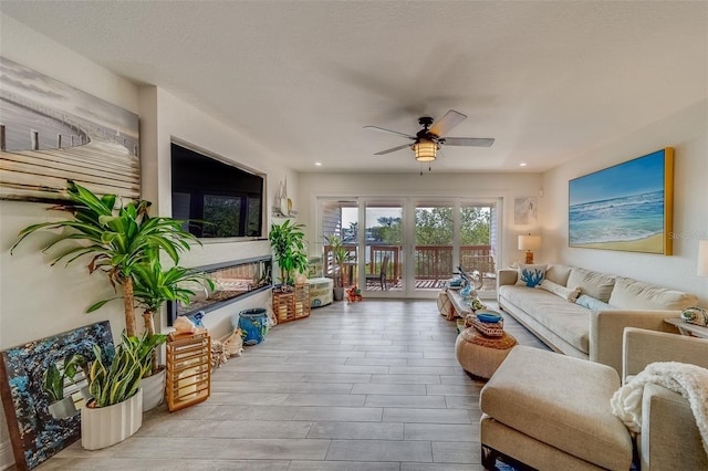 living room with a textured ceiling and ceiling fan