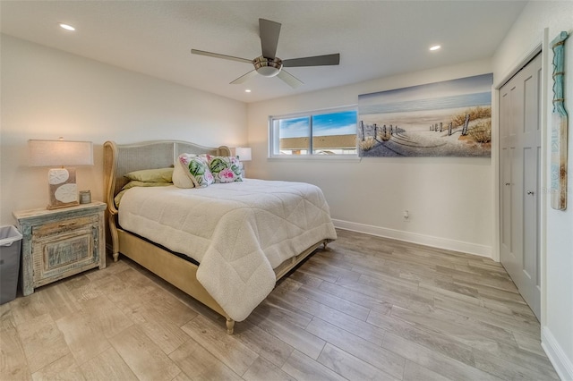 bedroom with ceiling fan, light wood-type flooring, and a closet