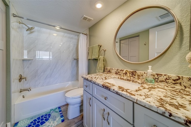 full bathroom with toilet, vanity, a textured ceiling, and shower / tub combo with curtain