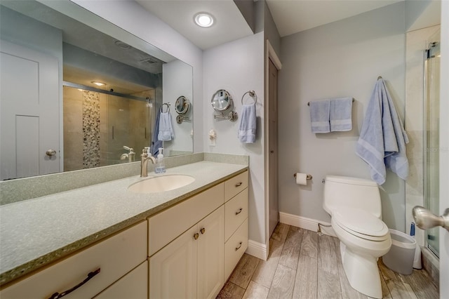 bathroom with walk in shower, vanity, and toilet