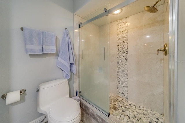 bathroom with toilet and a shower with shower door