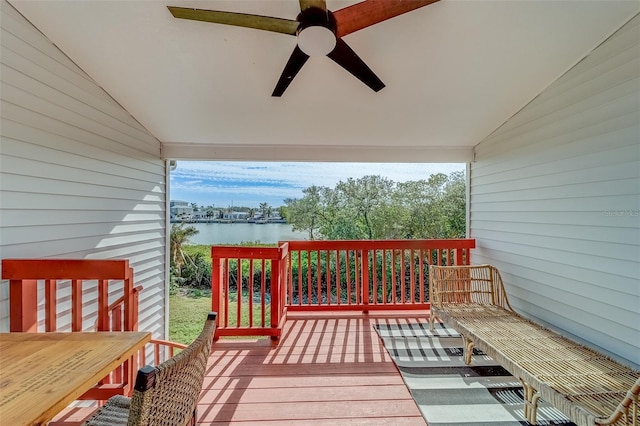 wooden deck with ceiling fan and a water view