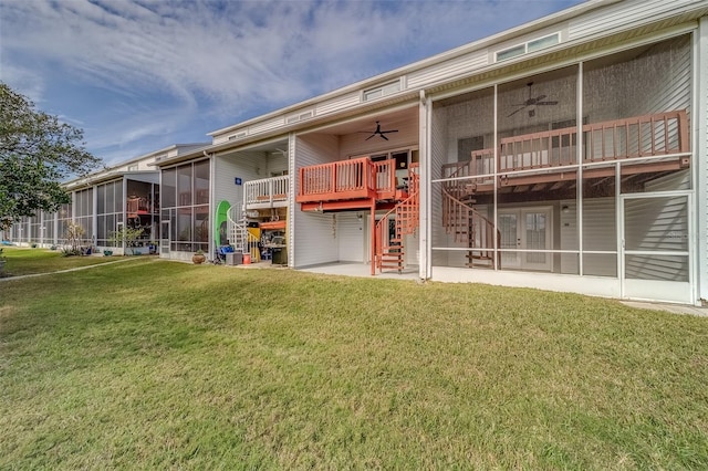 back of property featuring a patio, a yard, ceiling fan, a sunroom, and a deck