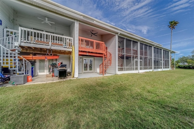 rear view of house featuring ceiling fan, a yard, and a sunroom