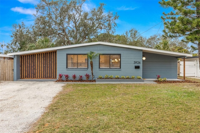 single story home featuring a front lawn and a carport