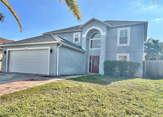 view of property featuring a garage and a front lawn