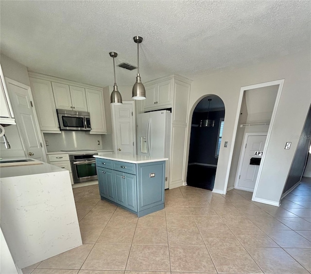 kitchen featuring appliances with stainless steel finishes, a center island, white cabinets, and sink