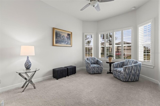 living area featuring carpet floors, ceiling fan, and baseboards