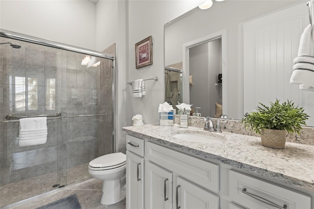 full bath with a stall shower, vanity, toilet, and tile patterned floors