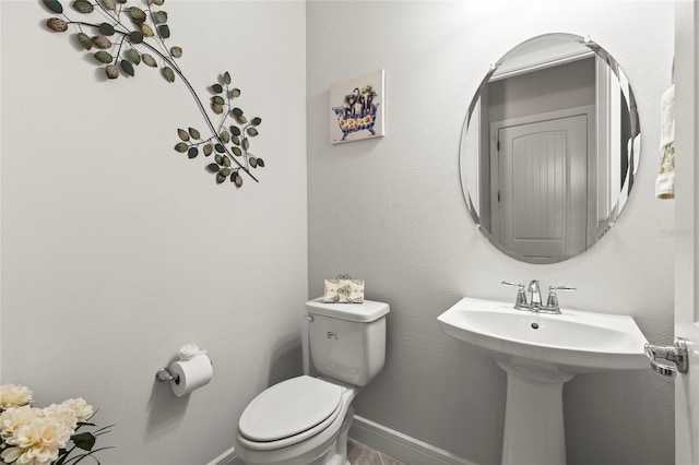 bathroom with toilet and baseboards