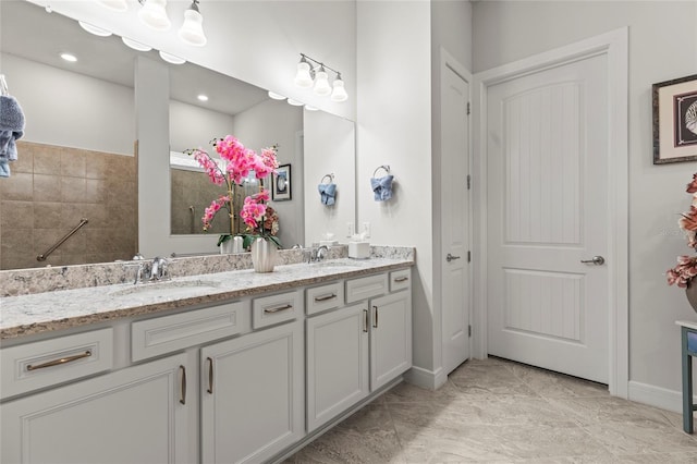 full bathroom featuring double vanity, a sink, and baseboards