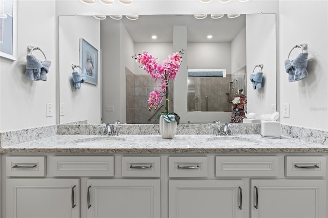 full bath featuring a walk in shower, double vanity, a sink, and recessed lighting