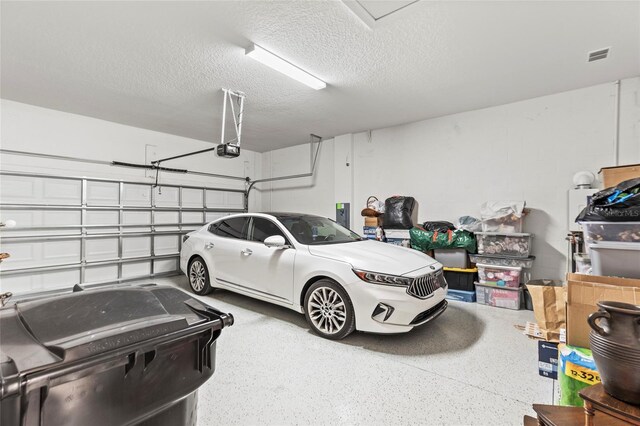 garage with a garage door opener and visible vents