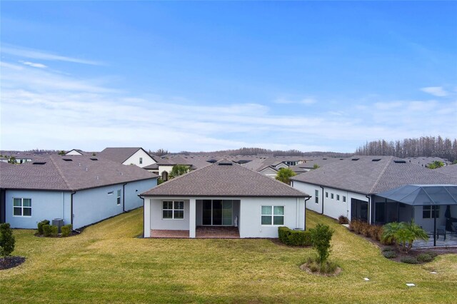 back of house featuring a shingled roof, central air condition unit, a yard, and stucco siding