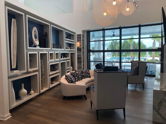 living area featuring a wall of windows and dark wood-style flooring