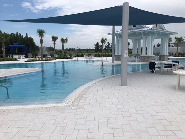 community pool with a patio area and a gazebo