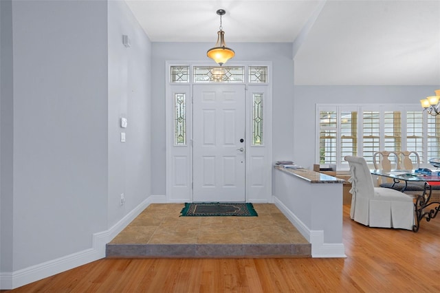 foyer with light hardwood / wood-style floors and a notable chandelier