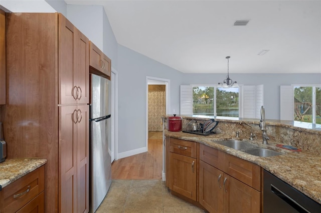 kitchen featuring sink, an inviting chandelier, black dishwasher, stainless steel refrigerator, and a wealth of natural light