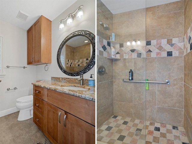 bathroom with tiled shower, vanity, and toilet