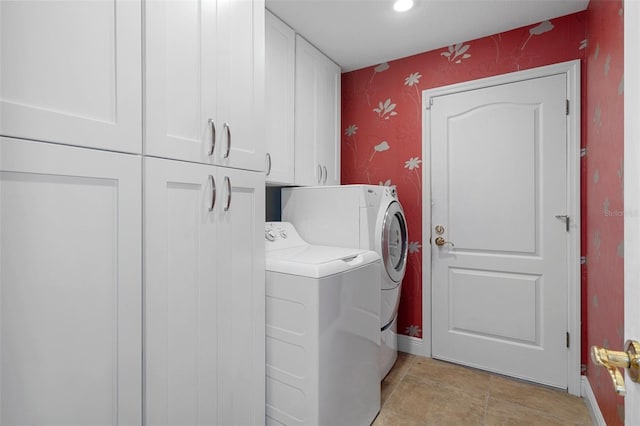 laundry room featuring cabinets and washer and clothes dryer