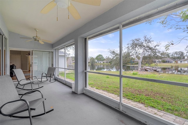 sunroom with lofted ceiling, ceiling fan, and a water view