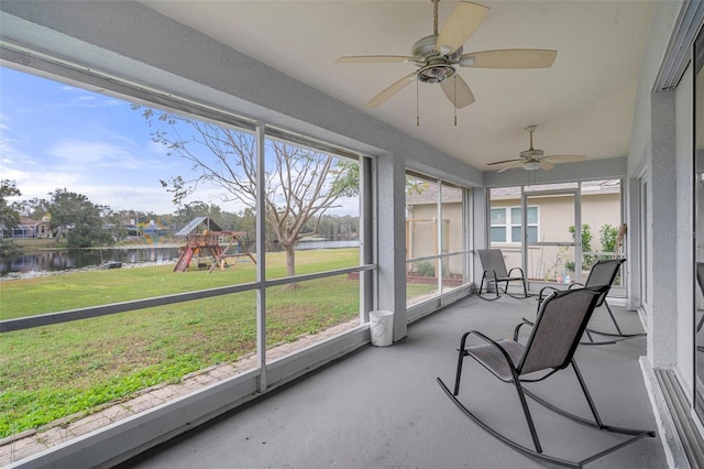 sunroom / solarium featuring ceiling fan and a water view