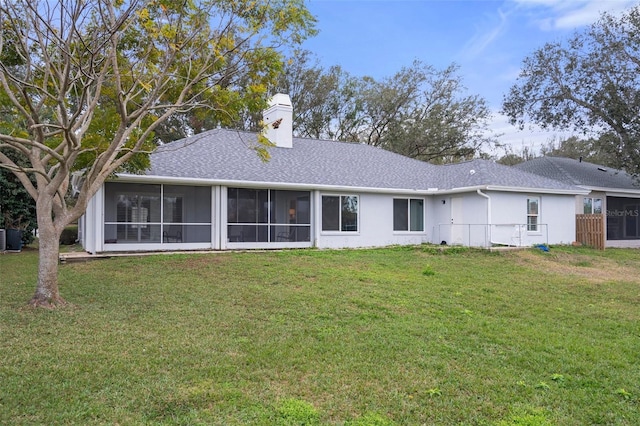 back of property with a lawn and a sunroom