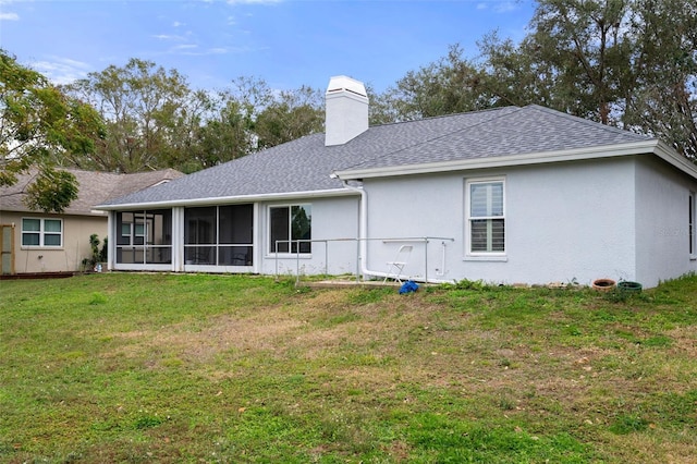 back of house featuring a lawn and a sunroom