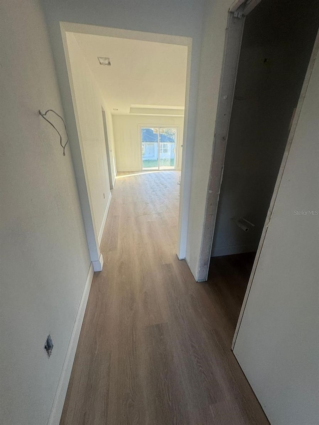 corridor with hardwood / wood-style flooring