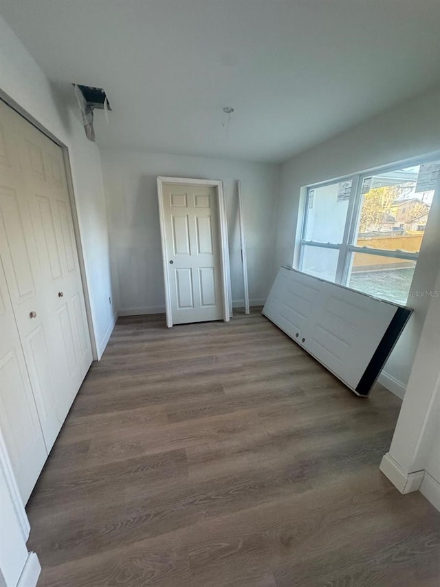 unfurnished bedroom featuring a closet and dark hardwood / wood-style floors