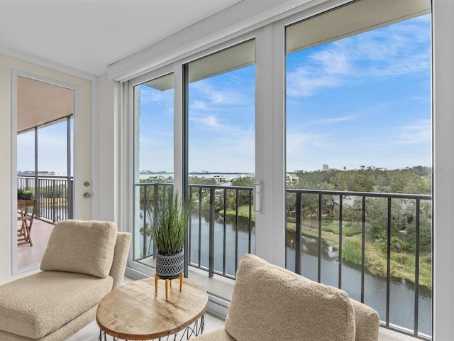 sunroom with a water view and a baseboard heating unit