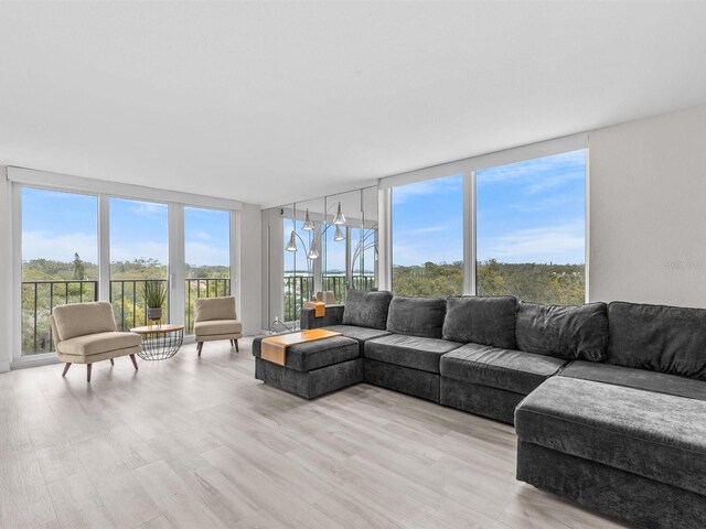 living room with a wall of windows and light wood-type flooring