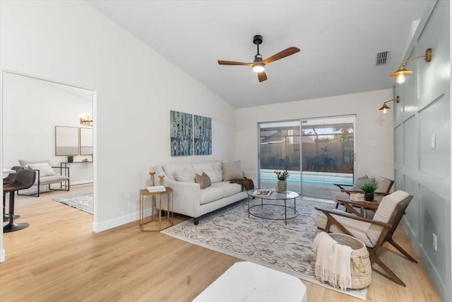 living room featuring lofted ceiling, ceiling fan, and light wood-type flooring