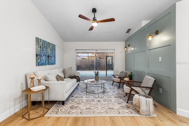 living room featuring lofted ceiling, light wood-type flooring, and ceiling fan