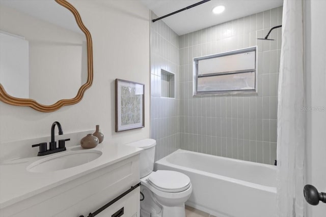 full bathroom featuring toilet, vanity, and tiled shower / bath combo