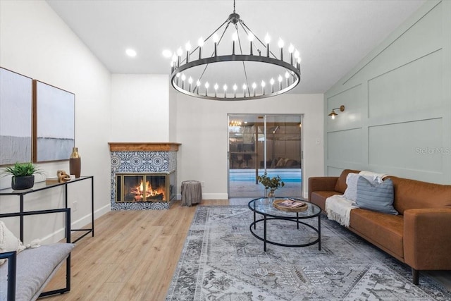 living room with a tile fireplace and light wood-type flooring