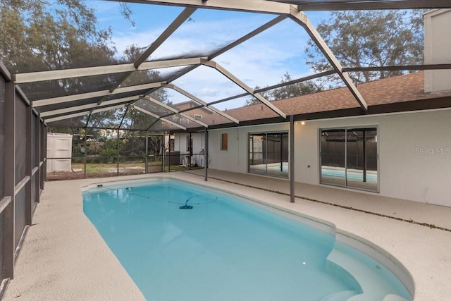 view of pool with glass enclosure and a patio