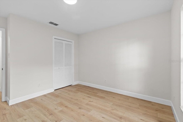 unfurnished bedroom featuring a closet and light hardwood / wood-style flooring